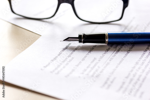 workspace with document, glasses and pen for sign for businessman day