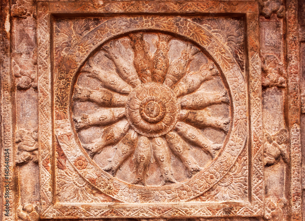 Great example of Indian rock-cut architecture. Ceiling with carved fish inside a wheel of life. 6th century cave temple in town Badami, India.
