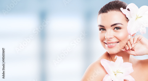 Beautiful Smiling Caucasian Woman with Clean Fresh Skin close up. Young model on blue window background