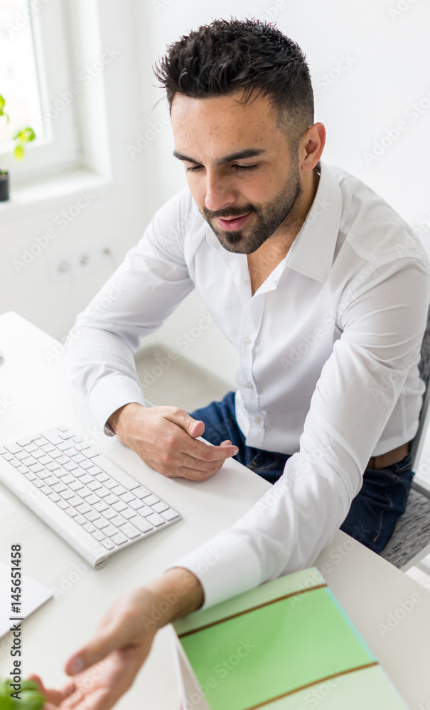 Young businessman working at office on computer desk Young businessman working at office on computer desk