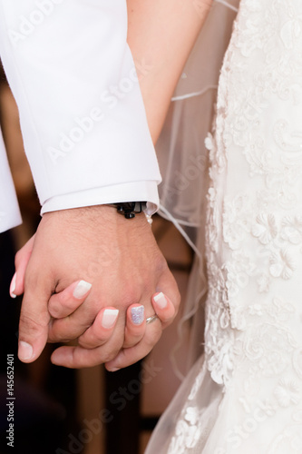 Bride and groom holding hands during wedding ceremony
