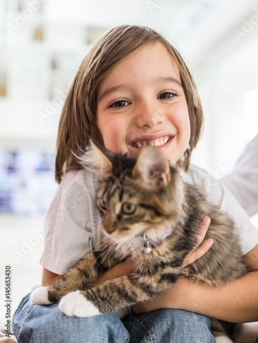 Happy kid at home playing with kitty cat