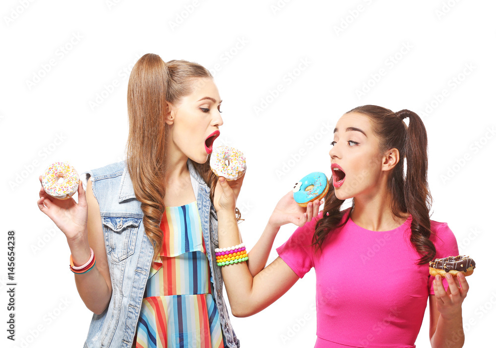 Funny young women with tasty donuts on white background Funny young women with tasty donuts on white background