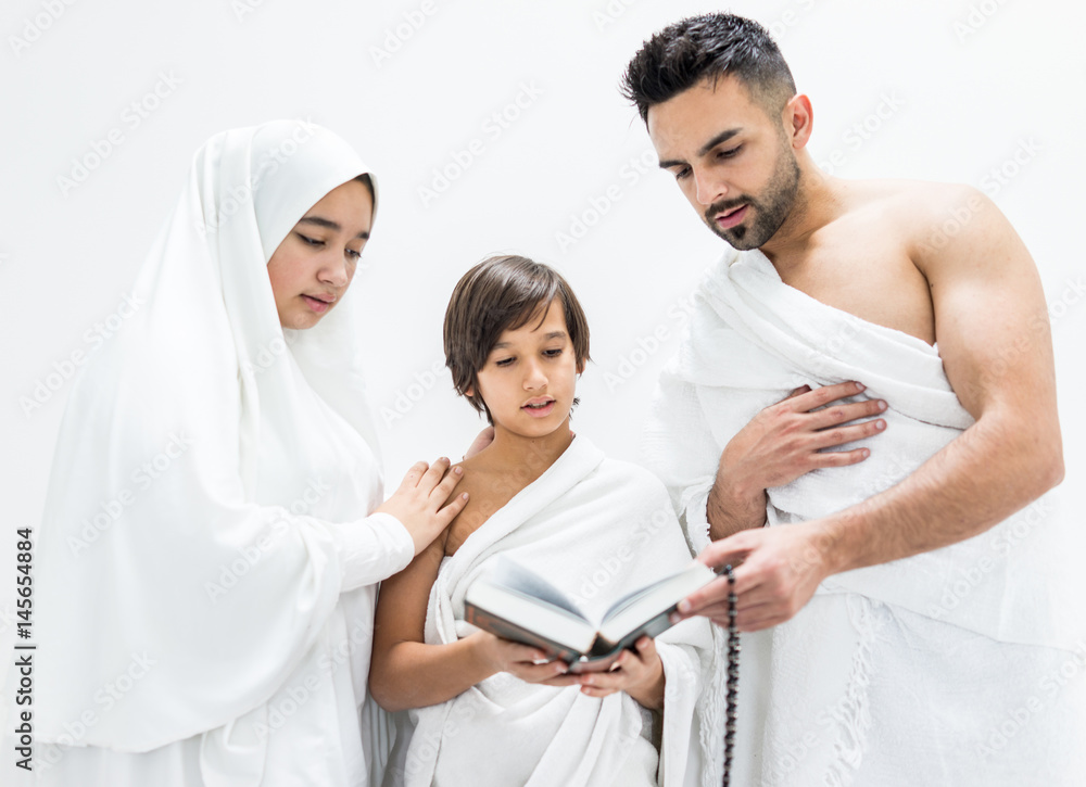 Obraz premium Muslim family posing as ready for Hajj visiting Kaaba in Mecca