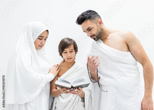 Muslim family posing as ready for Hajj visiting Kaaba in Mecca