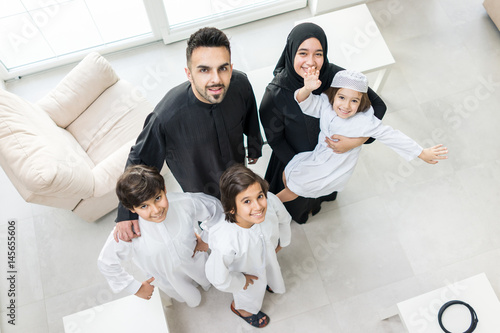 High angle view portrait of happy Arabic Muslim family at new modern home