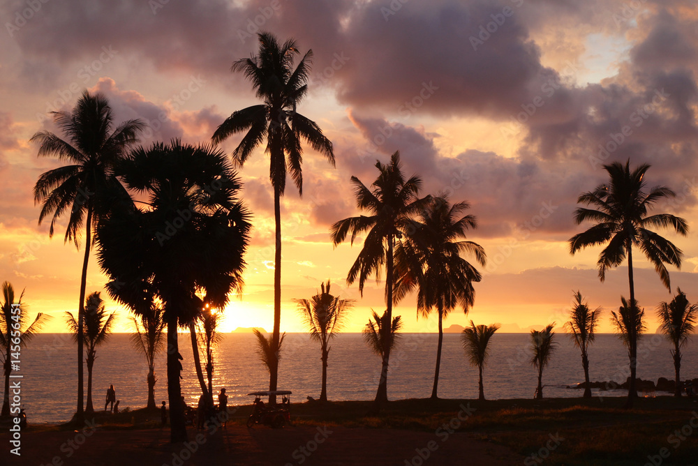 Travel to island Koh Lanta, Thailand. Palms on the background of the colorful sunset on a beach. Travel to island Koh Lanta, Thailand. Palms on the background of the colorful sunset on a beach.