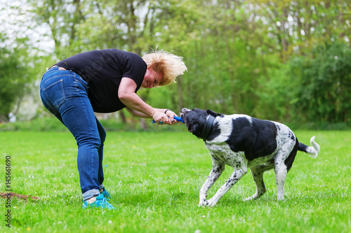 woman plays with her dog outdoors