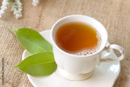 Close up organic tea in white cup with green leaf , Tea ceremony time concept