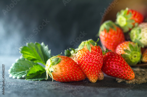 Close up Red Strawberries and leaf with black stone background
