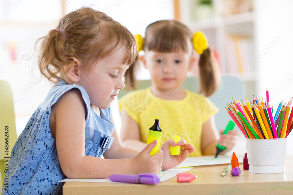 Two beautiful cute kids little girls are drawing at home or daycare centre. Two beautiful cute kids little girls are drawing at home or daycare centre.