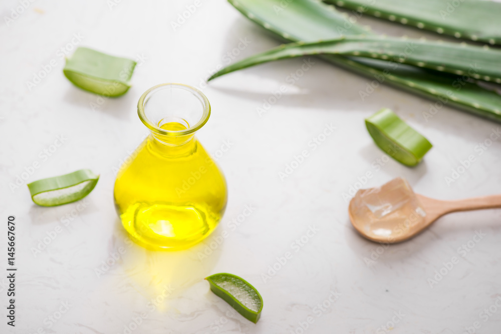 Aloe vera essential oil and aloe leaves on a white background. Aloe vera essential oil and aloe leaves on a white background.