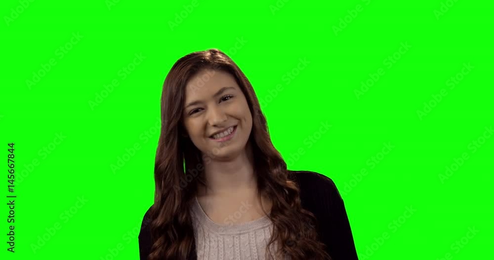 Smiling beautiful woman standing against green screen Smiling beautiful woman standing against green screen