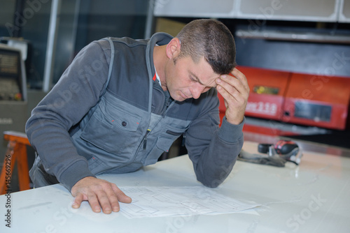 Tableau sur toile tired worker studying the bluerprint