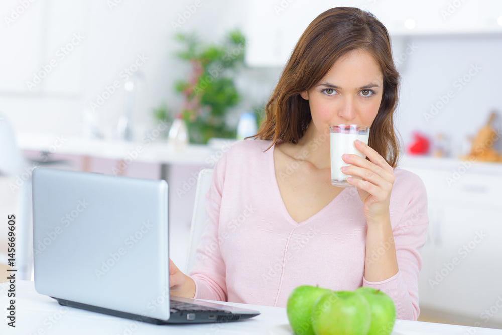 businesswoman with cup of coffe using laptop in kitchen businesswoman with cup of coffe using laptop in kitchen