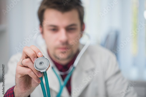 Doctor holding a stethoscope in his hand , close up
