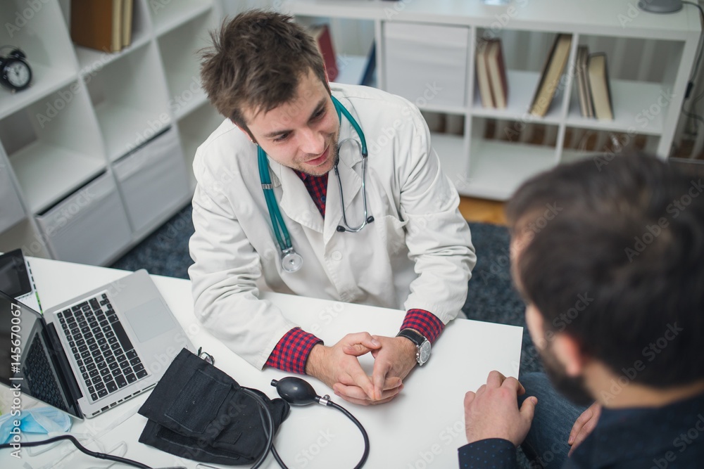 © Dzelat - Charming doctor and his patient talking about patient problems in hospital