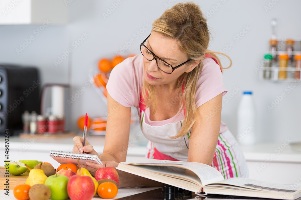 mature woman preparing meal in domestic kitchen mature woman preparing meal in domestic kitchen