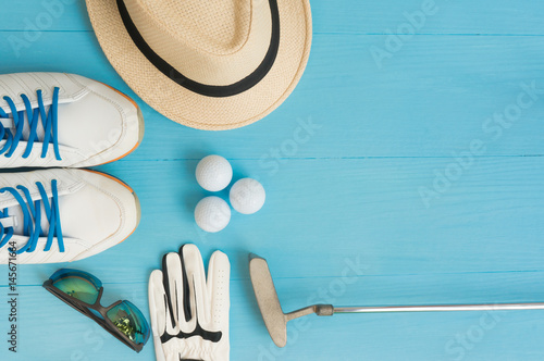 Golf concept : panama hat, glove, golf balls, golf clubs, golf shoes, sunglasses on wooden table. Flat lay with copy space. photo