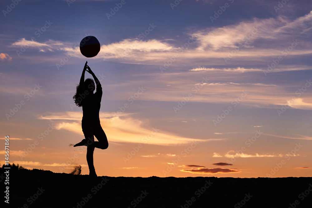 girl dancing with the ball on the sunset sky background