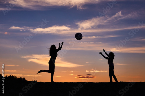 girl dancing with the ball on the sunset sky background