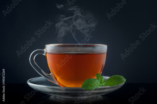 Cup tea with mint on a black background