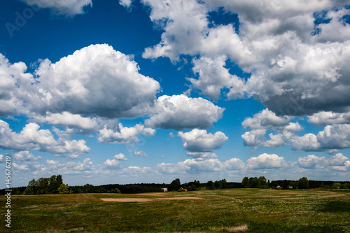 fields in country under blue sky with white clouds