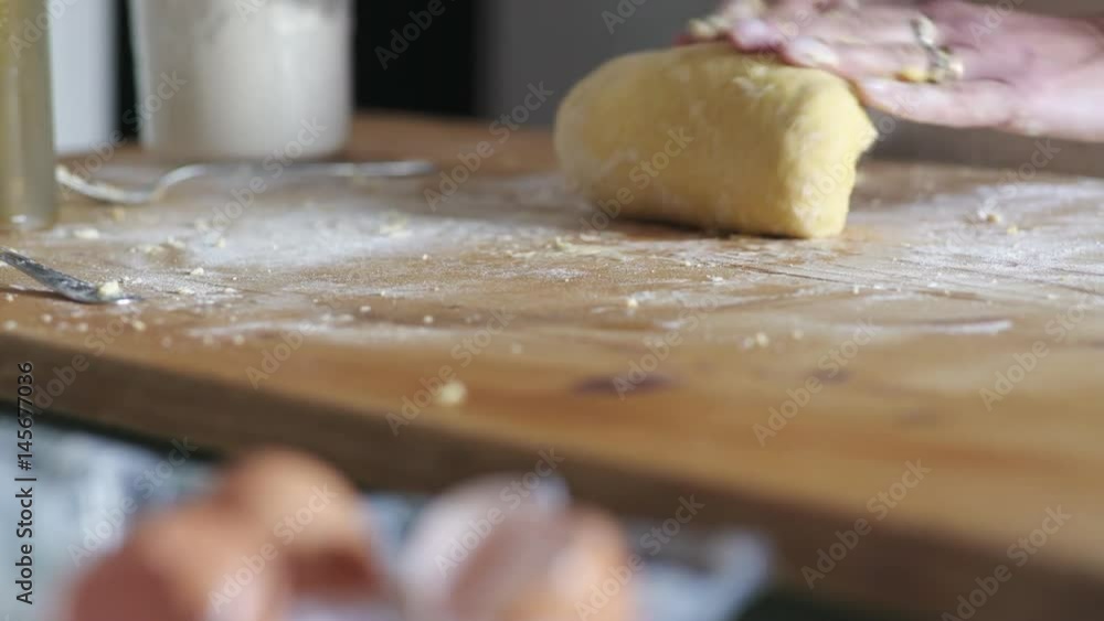 housewife's hands kneading the dough on wooden cutting board housewife's hands kneading the dough on wooden cutting board