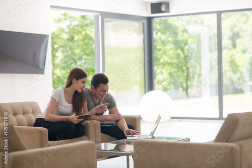 couple relaxing at  home with tablet and laptop computers