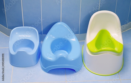 Potty training. Three kinds of pottys on the floor in bathroom.  Which potty our toddler choose to pee?