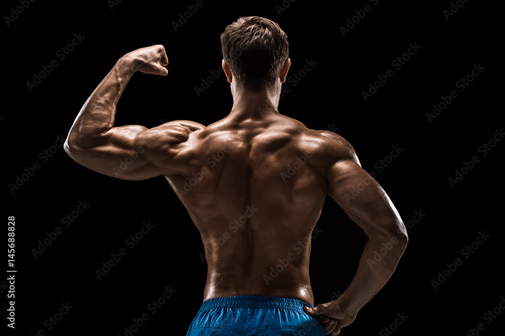 Strong Athletic Man Fitness Model posing back muscles, triceps over black background Strong Athletic Man Fitness Model posing back muscles, triceps over black background