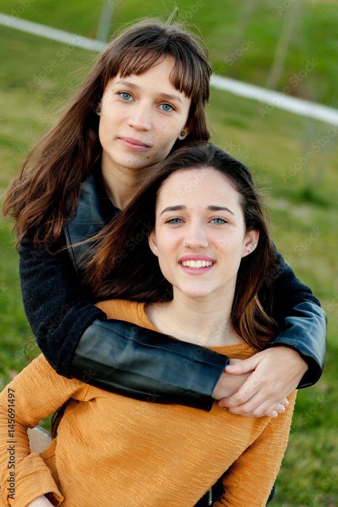 Naklejka premium Outdoor portrait of two happy sisters relaxed