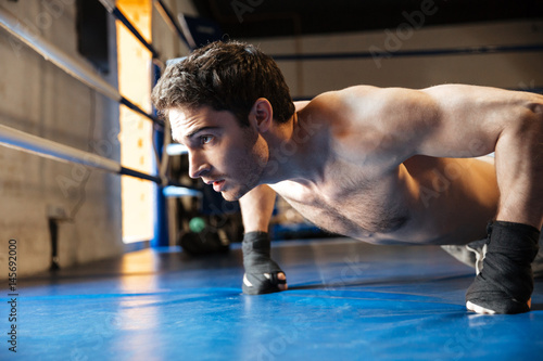 Side view of concentrated boxer doing push ups