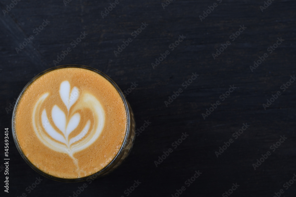 A cup of coffee cappuccino on a black wooden background A cup of coffee cappuccino on a black wooden background