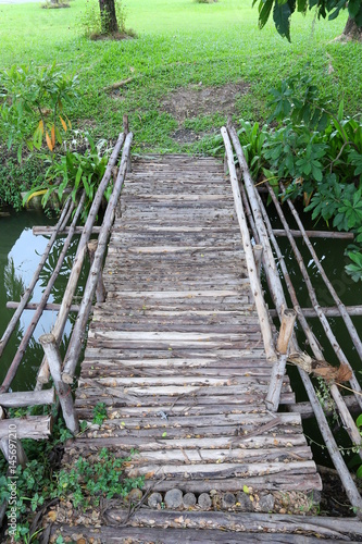 Fototapeta Naklejka Na Ścianę i Meble -  Wooden bridge across a pond
