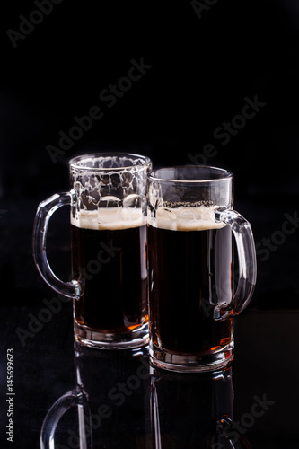 Two mugs of dark beer
