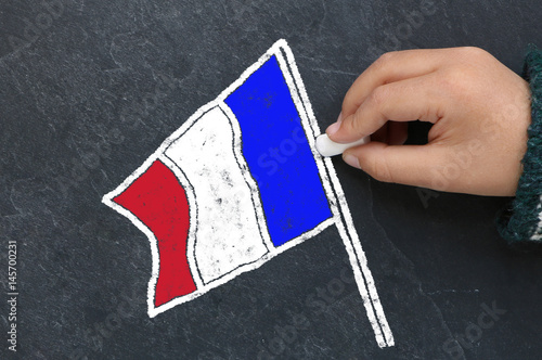 Enfant dessinant le drapeau français sur une ardoise