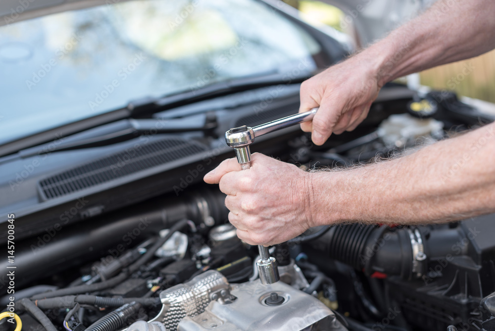 Hands of car mechanic working on car engine Hands of car mechanic working on car engine