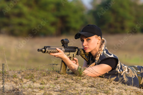 Beautiful woman ranger with rifle in camouflage