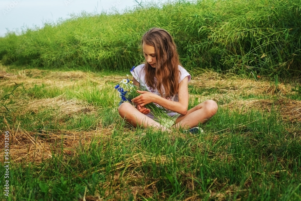 Girl child with a bouquet of flowers on a field on a summer day. Girl child with a bouquet of flowers on a field on a summer day.