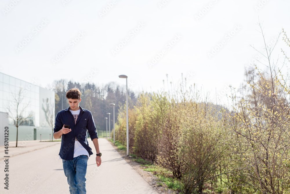 Junger Mann mit Handy auf Straße Junger Mann mit Handy auf Straße