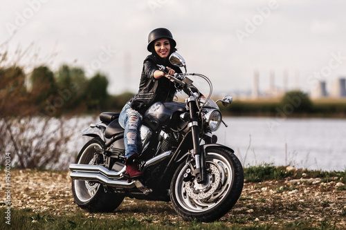 Beautiful brunette woman with a classic motorcycle  cinema bleach bypass effect 