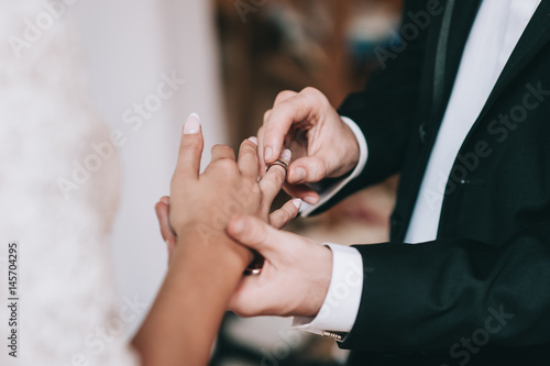Loving couple holding hands with rings against wedding dress © jul14ka