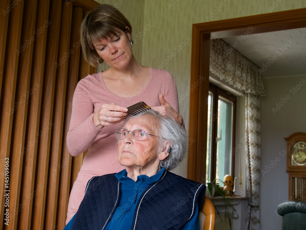 Junge Frau kämmt Seniorin Junge Frau kämmt Seniorin