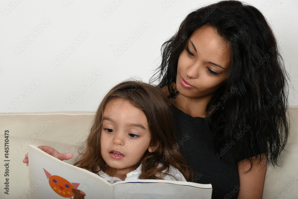 jeune mère apprenant à lire à sa fille jeune mère apprenant à lire à sa fille
