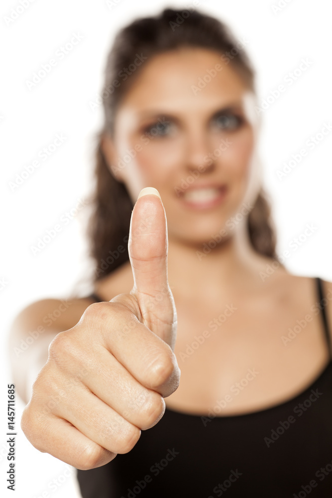 young beautiful brunette showing thumbs up young beautiful brunette showing thumbs up