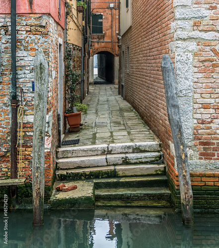 The ancient narrow strteet after repeated repairs - Venice, Ital photo