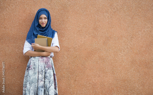 Happy asian girl standing and holding notebook paper.