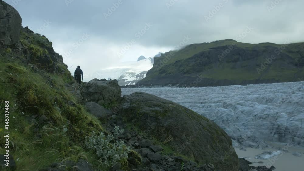 man walking toward glacier field in Iceland man walking toward glacier field in Iceland
