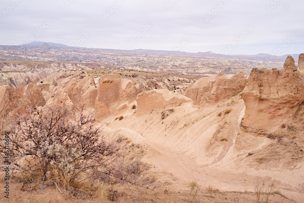 Fototapeta premium Travel and tourism in Turkey. Famous sightseeing Cappadocia, Anatolia. Beautiful landscape with mountains, caves and cloudy sky.